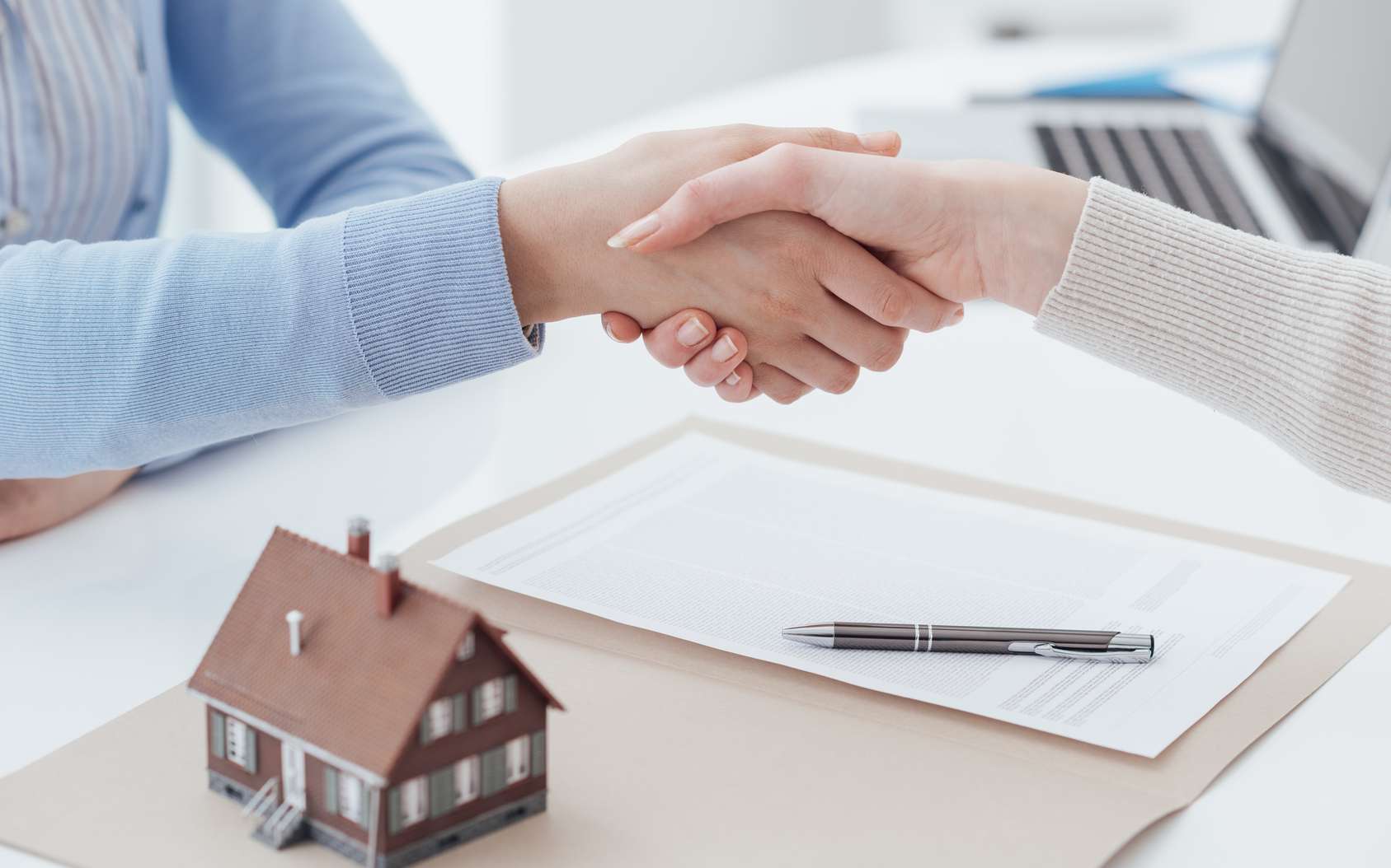 Poignée de main entre deux personnes ayant signé un contrat de vente immobilier