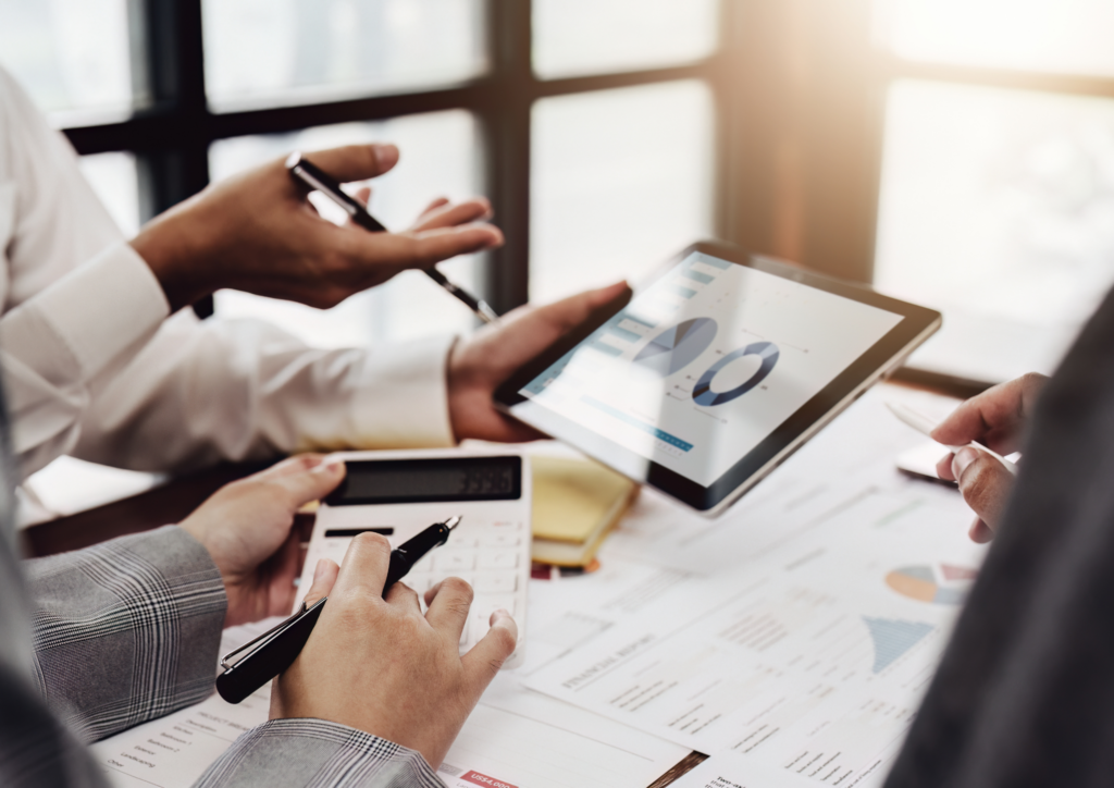 Drei Personen schauen sich Auswertungen auf einem Tablet an und diskutieren über die Inbound-Lead-Generierung im Bereich der Immobilien.